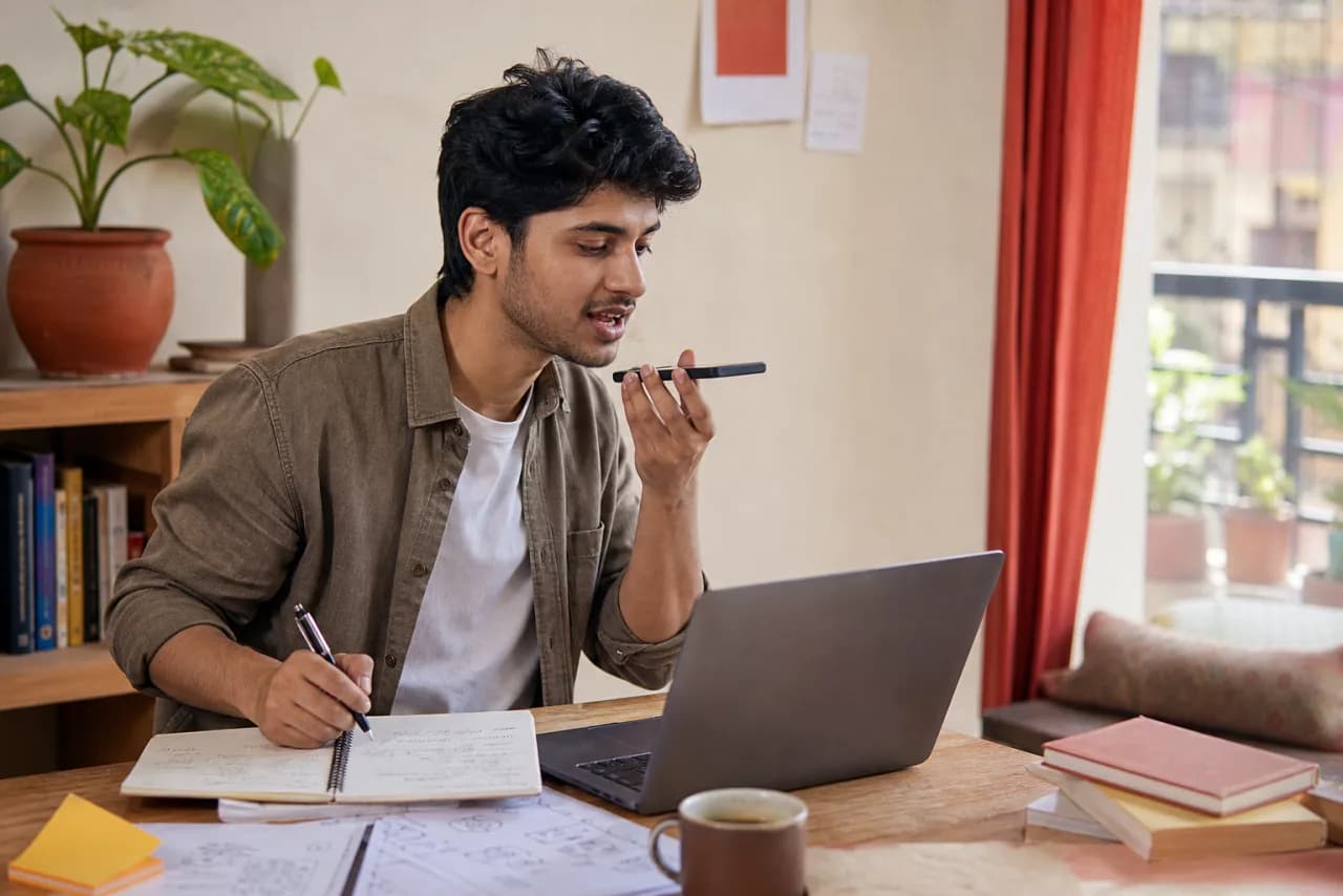 A young Marathi-speaking founder dictating an early business idea while sketching a plan