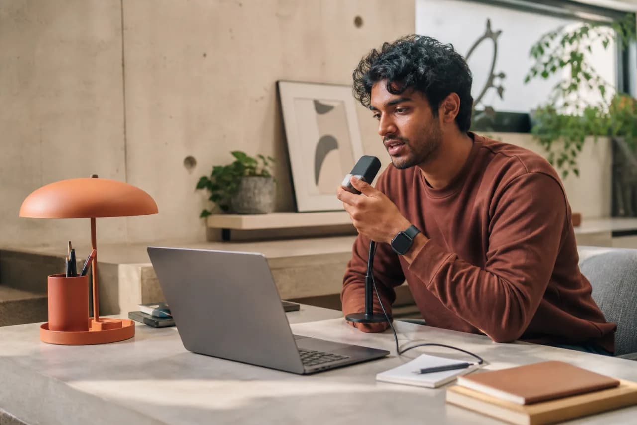 A young Telugu-speaking product builder dictating a launch note into a compact microphone
