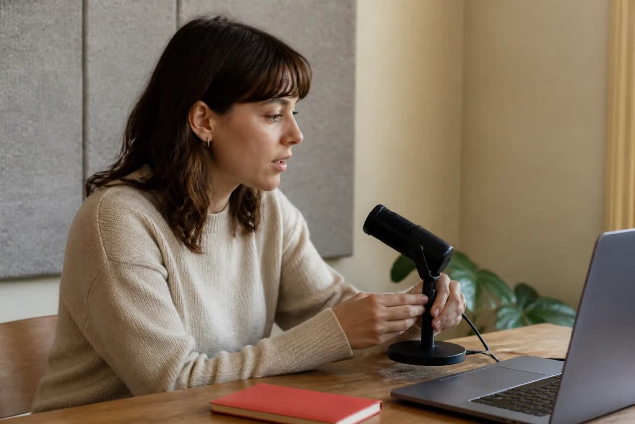 A voice typing user positioning a compact microphone at a comfortable distance beside a laptop